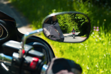 Motorcycle on the rural road in the mirror