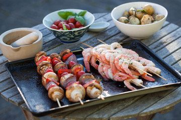 barbecue in the garden - summer- prawns and vegetables on skewers