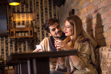  Beautiful young couple drinking coffee in cafe.
