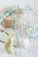 Fototapeta na wymiar Mint green lit candle in white lantern with gift
