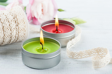 Pink eustomas on a white wooden board, lit candles