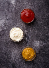 Set of different sauces: mustard, ketchup, mayonnaise.