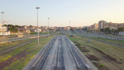 Fototapeta na wymiar Vista aerea dei binari di una ferrovia e panorama della città di Roma vicino la Stazione Tuscolana, poco prima del tramonto