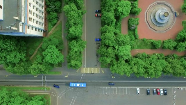 Vertical Aerial Top Down View Shot Traffic On The Roadway In The City In The Summer. Modern Urban Infrastructure With Cars, Sidewalks And Green Lawns, Small Traffic