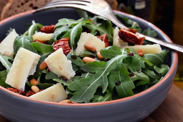 Rucolasalat mit Parmesan in Terracotta Schüssel, Nahaufnahme, Foodstyling