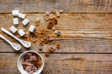 lumps of white and brown sugar on wooden table background top view mock up