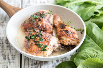 Fried golden chicken thighs with spices and herbs. Baked chicken legs