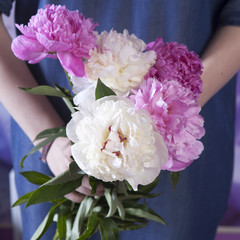 Wedding bouquet of a bride from a peony in hand of bride