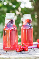 Lemonade detox strawberry basil. refreshing drink with fresh strawberry and basil on the background of the garden