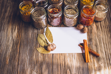 Various colorful kinds of spices on rustic wooden table, top view with copy space