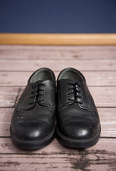 Old Black Dress Shoes on a Wooden Floor