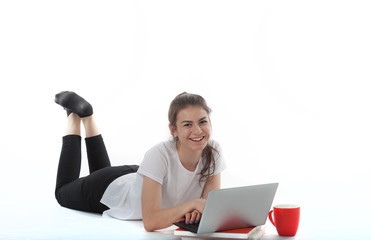 Young women is sitting on white background with laptop, cup, books and papers. Student girl studying, freelances is working on computer, girl is learning. 
