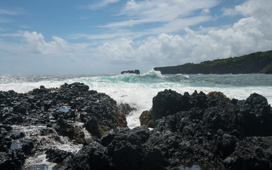 Fototapeta na wymiar Pacific ocean breaks against lava rocks at Keanae