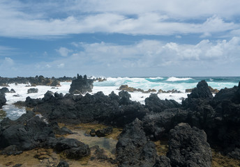 Pacific ocean breaks against lava rocks at Keanae