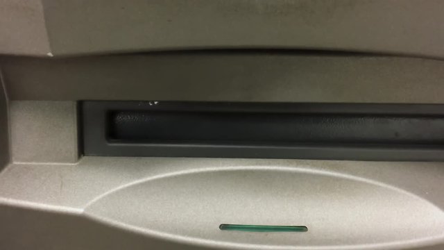 British ATM bank cash machine with closeup shot of withdrawing British pound notes