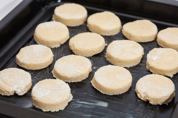 Fototapeta na wymiar Butter Cookies Preparation : Round cut cookies on baking sheet