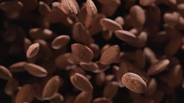 Almond flies after being exploded against black background. Shot with high speed camera, phantom flex 4K. Slow Motion.