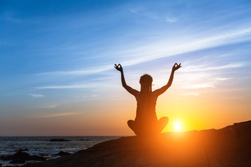 Fototapeta na wymiar Yoga silhouette. Meditation fitness woman on the Sea beach during amazing sunset. Healthy lifestyle.