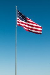 American Flag with the background of a blue sky.  