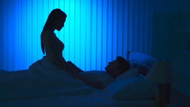 The man and woman kissing on the bed. night time