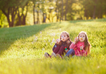 Fototapeta premium Girls play with soap bubbles.