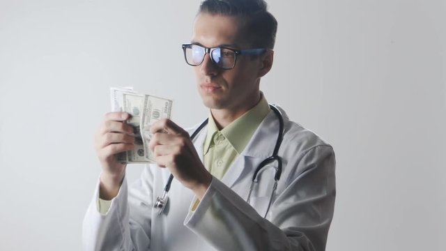 Doctor counts the money. A bribe to a medical worker. Expensive medicine.
