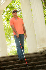 Blind Man Walking And Descending Stairs In City Park