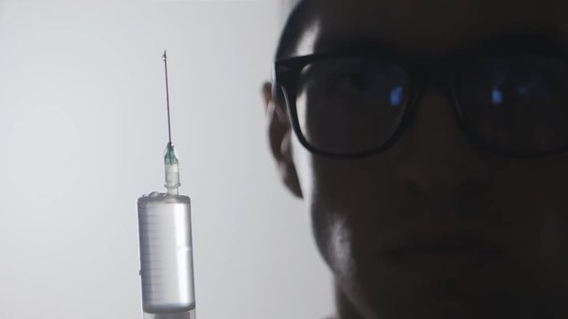 Close up Portrait of a doctor with a syringe. An injection