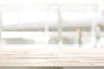 Wood table top on white blur abstract background from outdoor covered walkway in the city