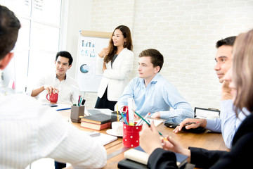 Fototapeta premium Young interracial business people listening to their colleague in the meeting