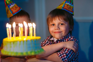 Children's birthday. Children near a birthday cake with candles.