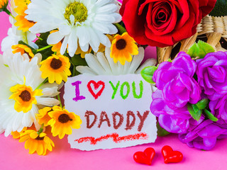 Father's day concept. I LOVE YOU DADDY message with white and yellow flower, two red heart and black Mustache on pink background