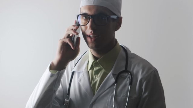 The doctor speaks on a mobile phone. A medical worker makes a phone consultation.