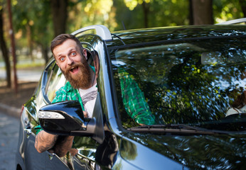 Cheerful bearded man in the car.