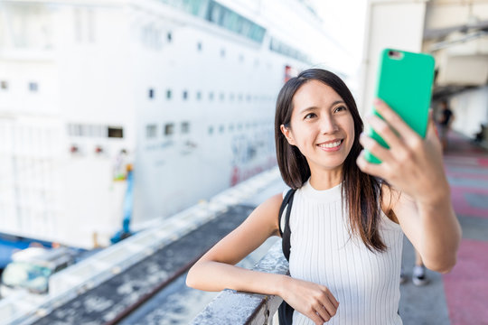 Woman taking selife by mobile phone in Cruise terminal