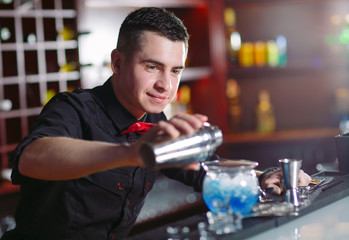 Bartender pouring fresh cocktail in fancy glass