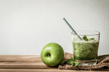 Healthy fresh  green smoothie juice in the glass bottle on wooden table for healthy detox and diet  habits concept