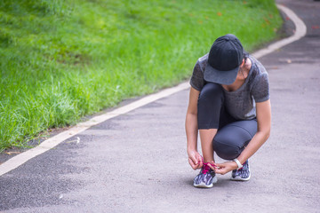 Tying laces of running shoes.