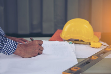 Construction engineers are looking at the blueprints on the table.