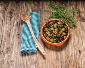 Fototapeta na wymiar Green and black olives with wooden spoon