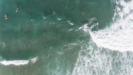 Obraz premium Aerial view of Surfer swimming on board near huge blue ocean wave
