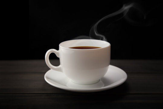 Fototapeta White coffee cup and coffee beans with smoke on black background