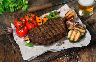Beef grilled steak with grilled vegetables and lager beer