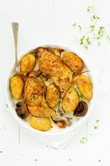 Baked chicken thigh with potatoes and vegetables.
