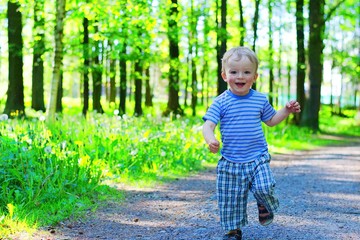 Happy toddler running along a forest path. Child concept.