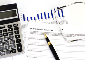 Obraz premium Calculator and fountain pen and eyeglasses for Businees plan concept