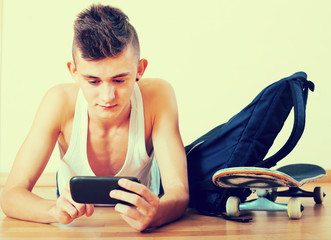 Male teenager playing with phone
