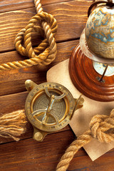 Compass and rope on wooden table. close up