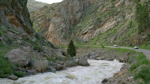 Spring run off of the Cache la Poudre River in the canyon above Fort Collins, Colorado with highway traffic