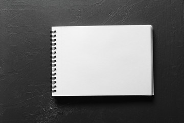 Blank sketchbook with white pages isolated on black background